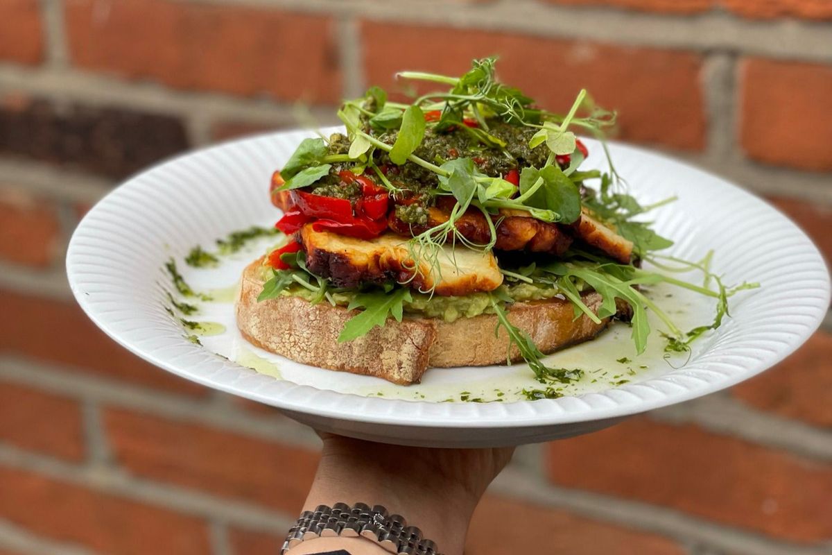 Sourdough toast topped with avocado, grilled halloumi and pesto.