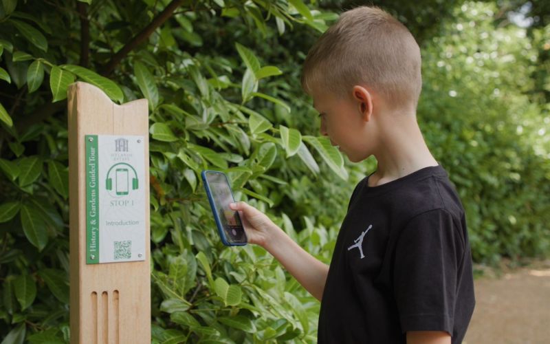 A young boy scanning a QR code on the Hylands History and Gardens Multimedia Tour.