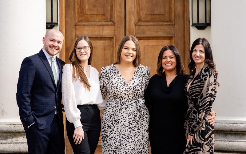 The Hylands Events Team smiling in front of Hylands House.